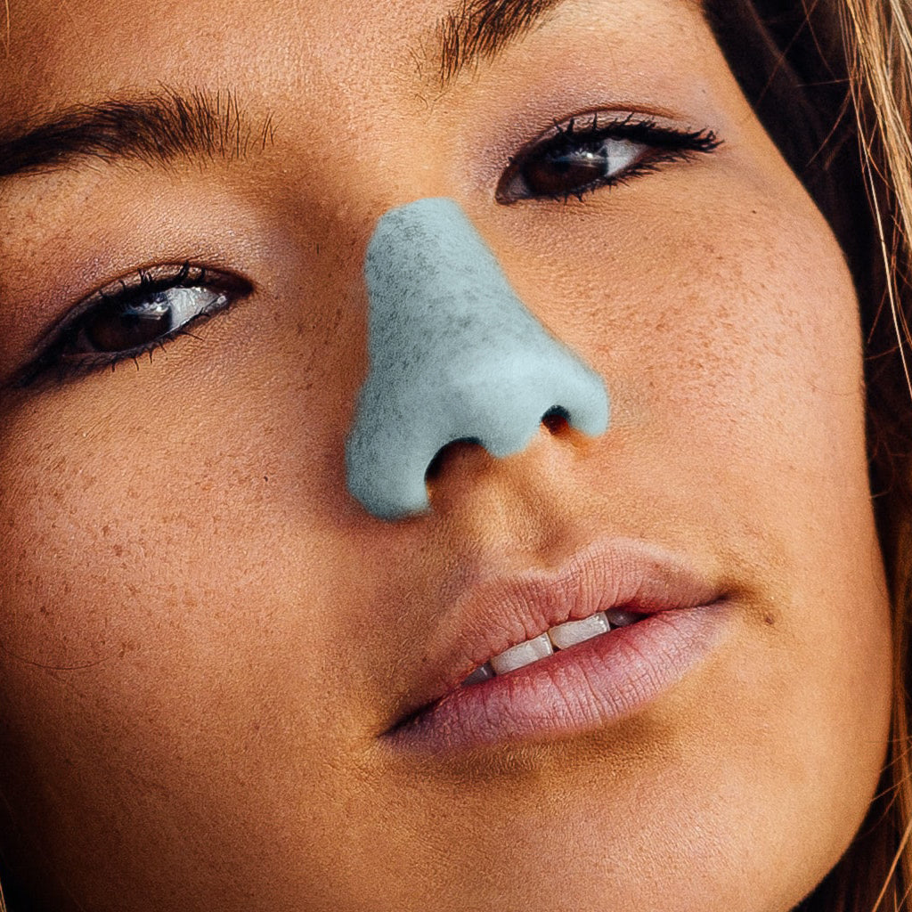 dark brown skin of girl up close face with blue nose painted